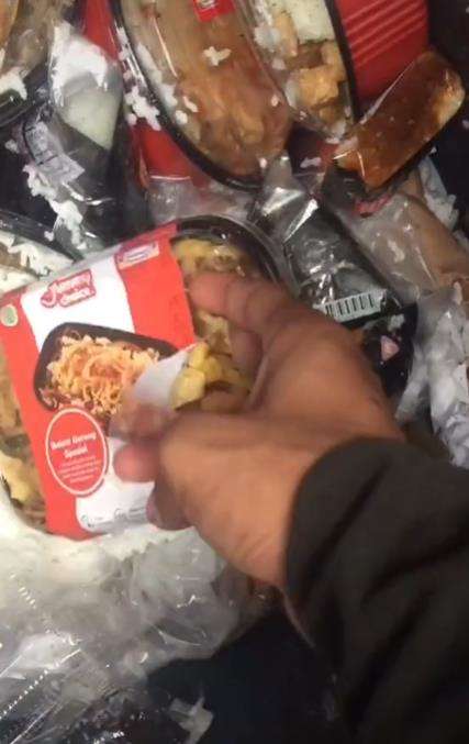 Dua pemuda makan dari tempat sampah.