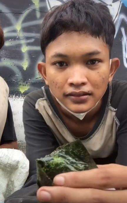 Dua pemuda makan dari tempat sampah.