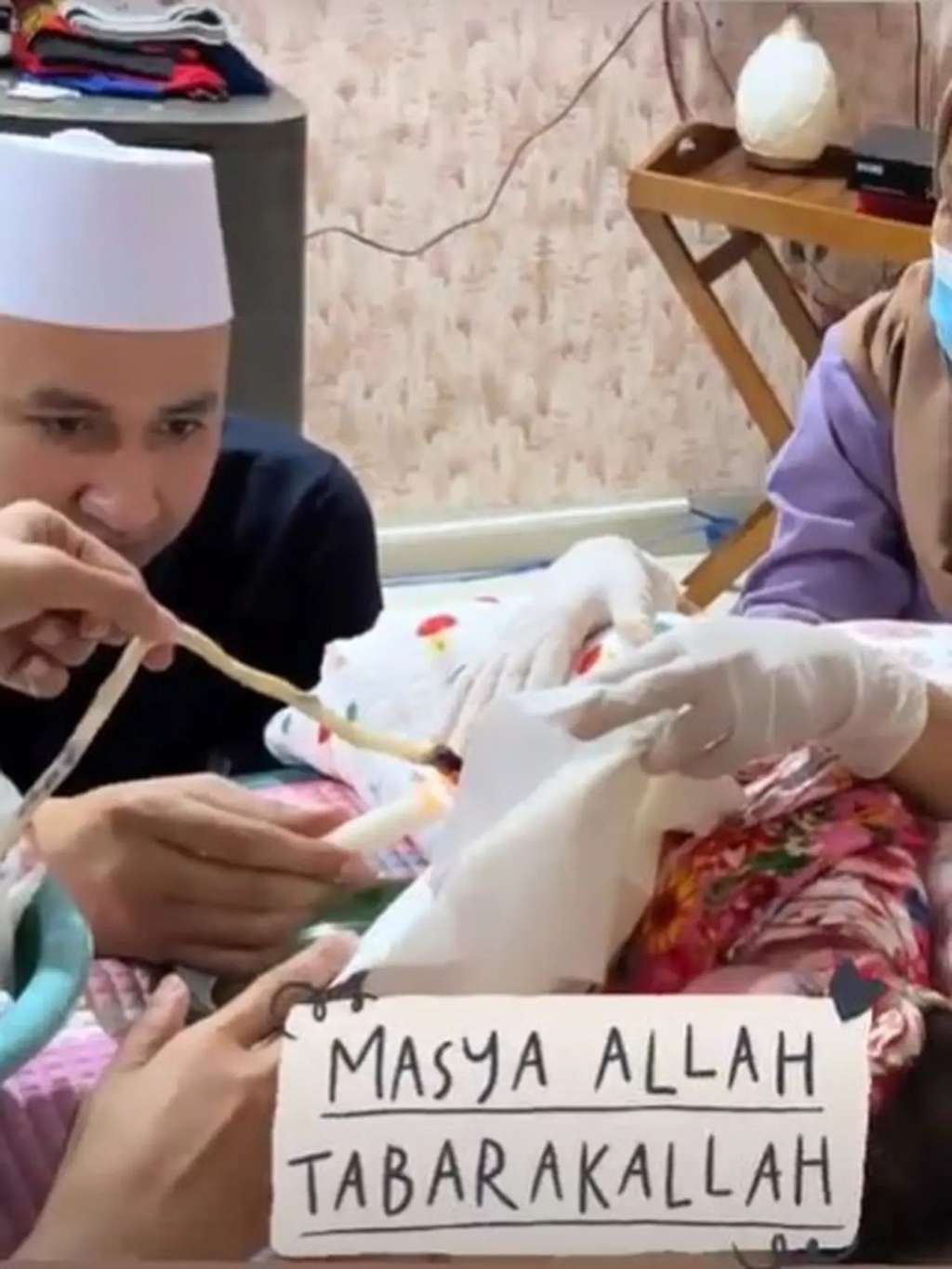Suami Kartika Putri saat memotong ari-ari anak kedua