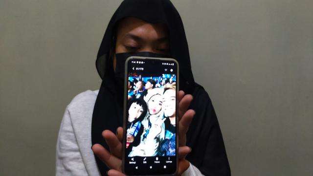 Elimiati menunjukkan foto bersama suami dan akanya di Stadion Kanjuruhan