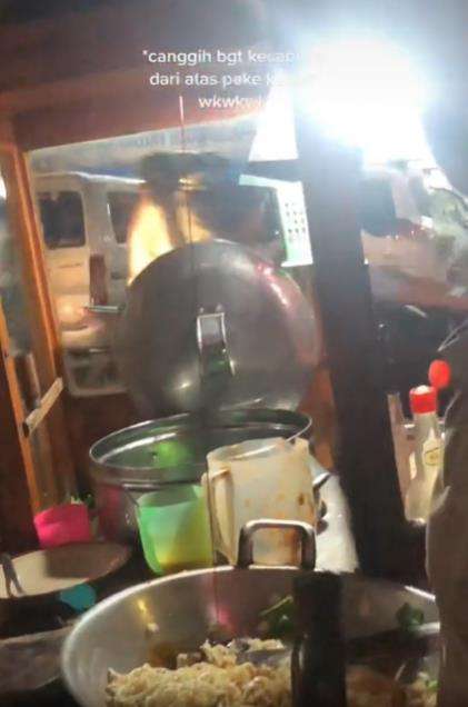 Penjual mie goreng tuang kecap pakai keran.