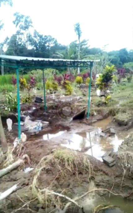 Area makam yang dilanda banjir akibat tanggul sungai jebol.