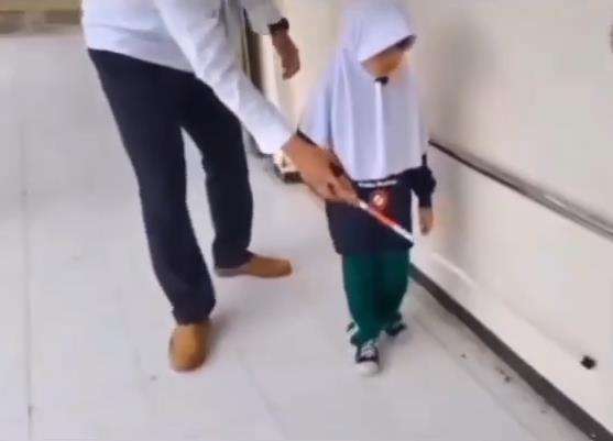 Guru mengajar murid penyandang tunanetra mengenal lingkungan.