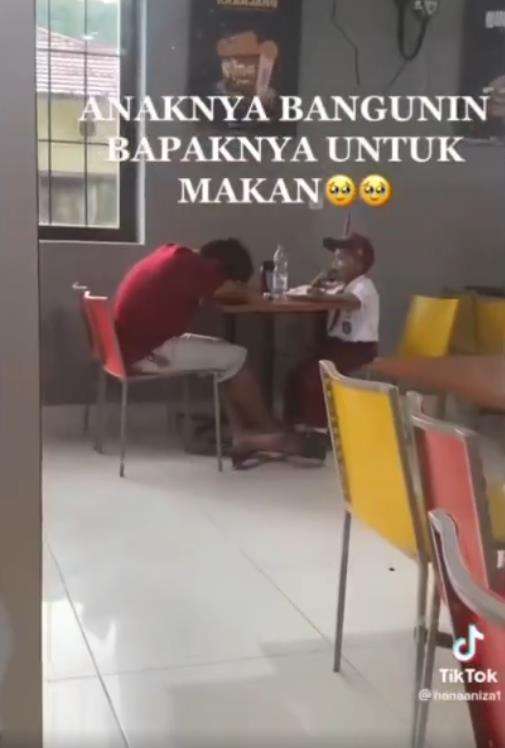 Ayah pura-pura tidur saat temani anak makan ayam goreng.