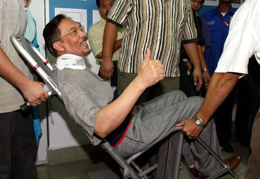Anwar Ibrahim tiba dengan kursi roda dan peyangga leher di pengadilan tahun 2004