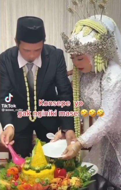Momen kocak pengantin pria potong tumpeng pernikahan.