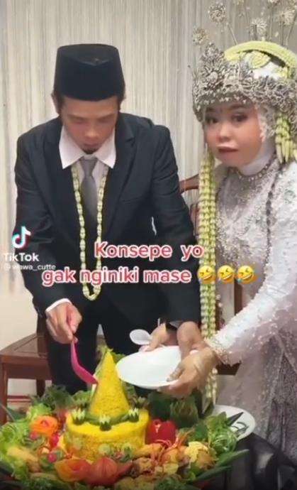 Momen kocak pengantin pria potong tumpeng pernikahan.