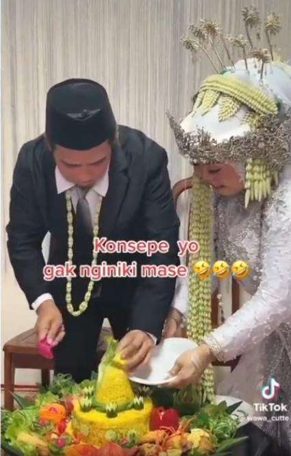 Momen kocak pengantin pria potong tumpeng pernikahan.