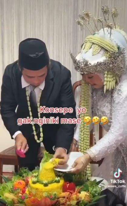 Momen kocak pengantin pria potong tumpeng pernikahan.