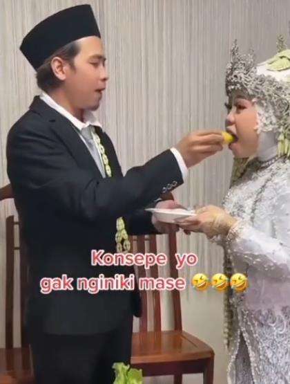 Momen kocak pengantin pria potong tumpeng pernikahan.