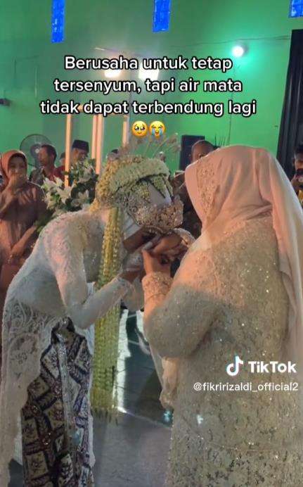 Pengantin wanita bawa foto orangtua di hari pernikahannya.