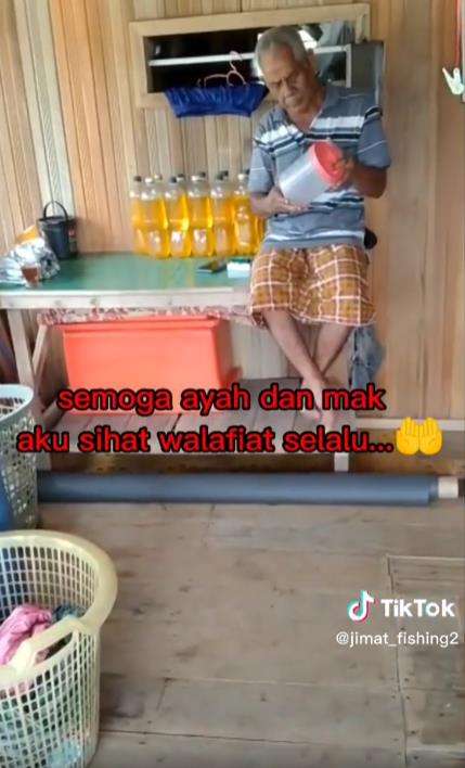 Che Ahmad tampak sedang bersantai di teras rumah apungnya.