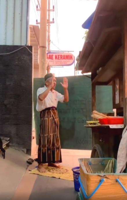 Viral penjual sate tengah sholat di belakang gerobaknya.