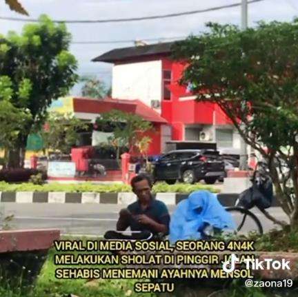 Gadis cilik sholat di pinggir jalan pakai mukena dari plastik.