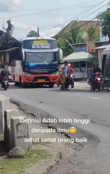 Aksi kondektur bus bantu nenek menyeberang jalan.