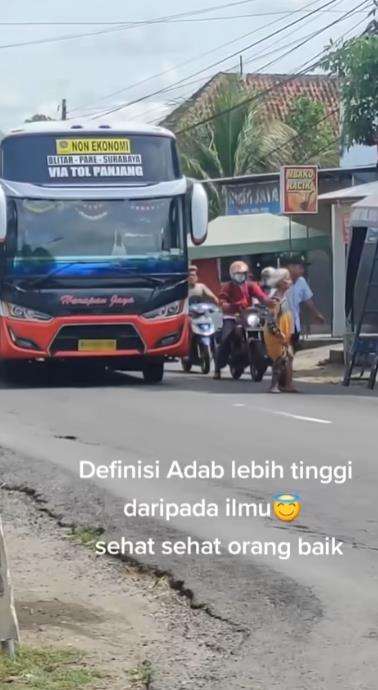 Aksi kondektur bus bantu nenek menyeberang jalan.