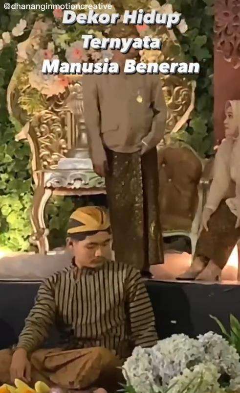 Dikira patung, dekorasi pelaminan ini ternyata manusia sungguhan.
