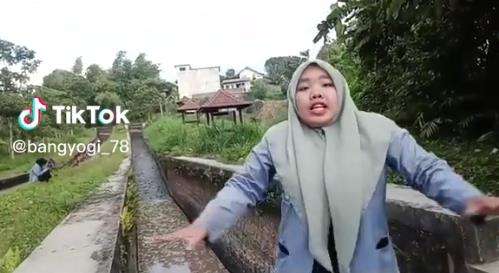 Buat konten sambil jalan mundur, gadis ini nyebur kali.