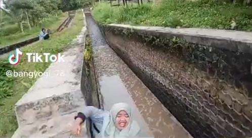 Buat konten sambil jalan mundur, gadis ini nyebur kali.