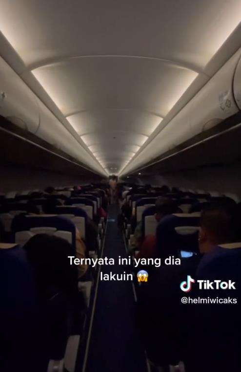 Penumpang nyalakan lampu baca selama penerbangan malam.