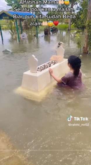 Momen Haru Wanita Ziarah dan Bersihkan Makam Ibunya yang Terendam Banjir