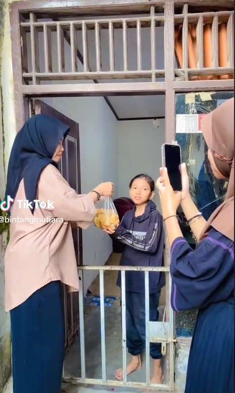 Wanita Bagi-bagi Bingkisan