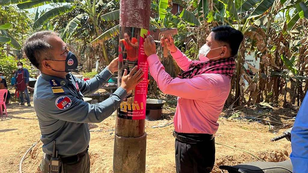 Petugas Kamboja tengah menempel poster kewaspadaan flu burung