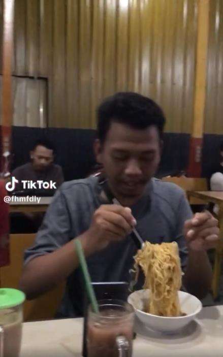 Aksi jahil nyolong mangkok teman yang lagi aduk mie.