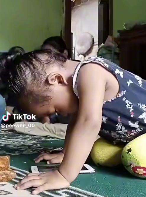 Tingkah kocak bocah main HP ketiduran.
