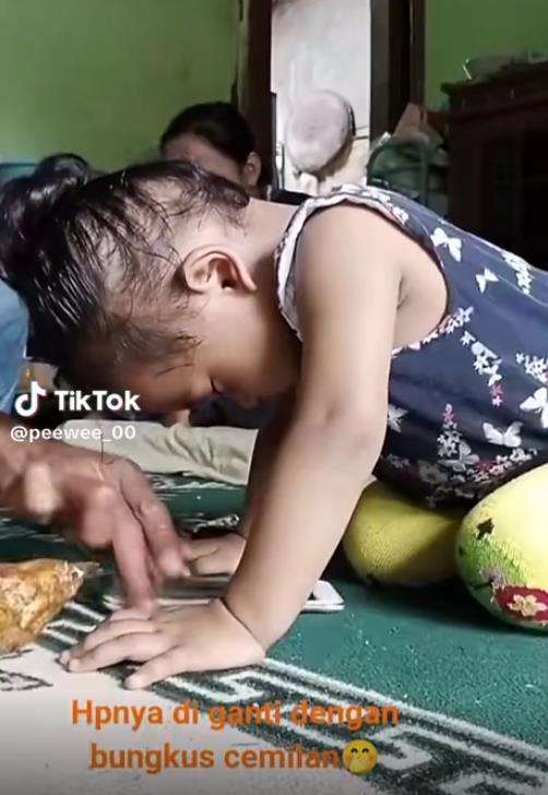 Tingkah kocak bocah main HP ketiduran.