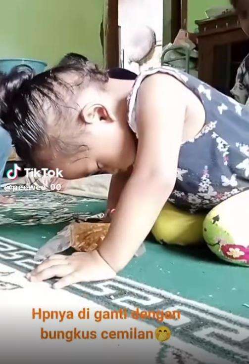 Tingkah kocak bocah main HP ketiduran.