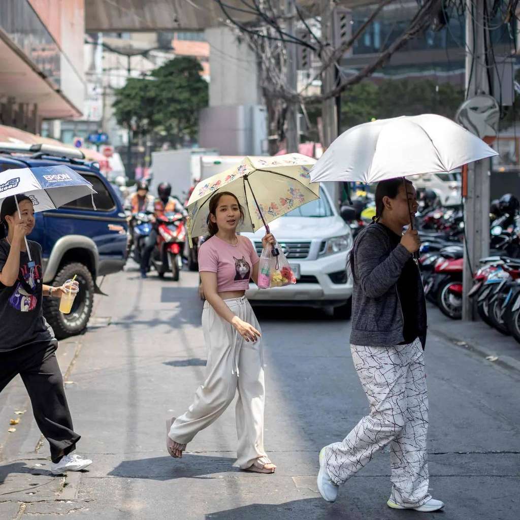 Warga Asia terpaksa menggunakan payung untuk menahan panas