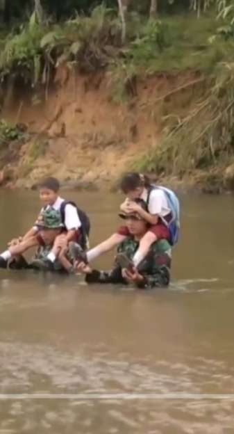 Momen TNI Wilayah Perbatasan Gendong Anak SD Menyebrang Sungai, Airnya Setinggi Dada Orang Dewasa