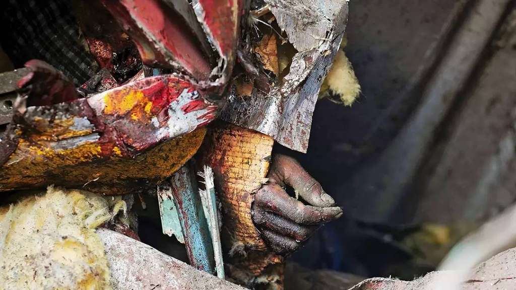 Salah satu tangan korban terlihat di kepingan kereta api yang bertabrakan di Odisha, India