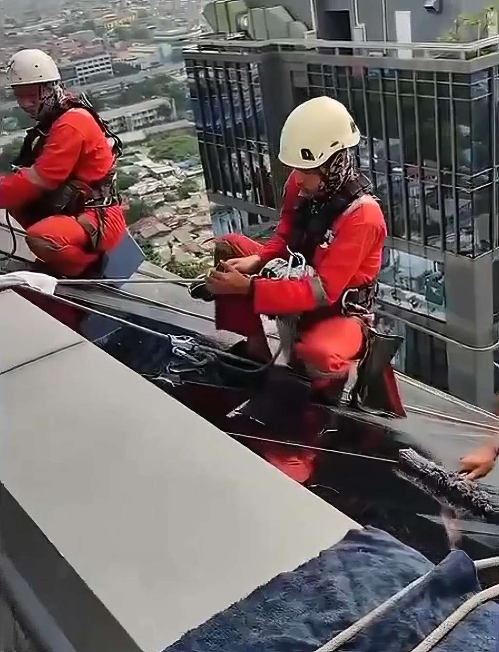 Aksi operator gondola saat bekerja di ketinggian puluhan hingga ratusan meter di atas permukaan tanah.