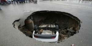 Mobil `Ditelan` Bumi di Tengah Jalan Raya