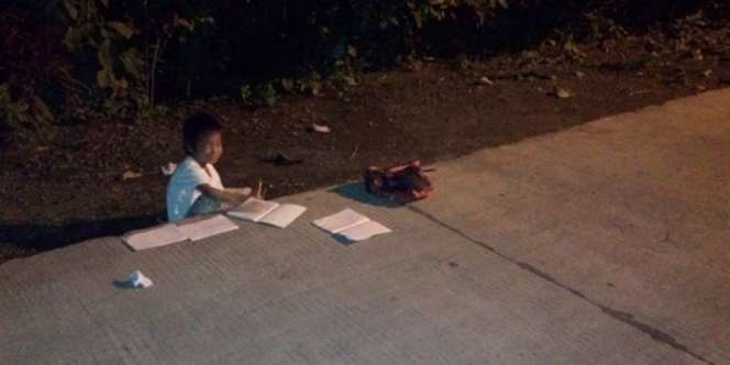 Tak Ada Listrik di Rumah, Bocah Belajar Ditemaram Lampu Jalan