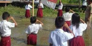 Haru, Anak SD Tetap Laksanakan Upacara di Tengah Banjir