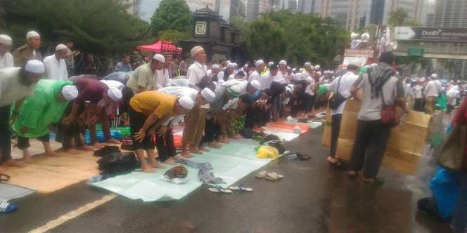 Massa di Jalan Sudirman Khusyuk Sholat di Bawah Guyuran Hujan