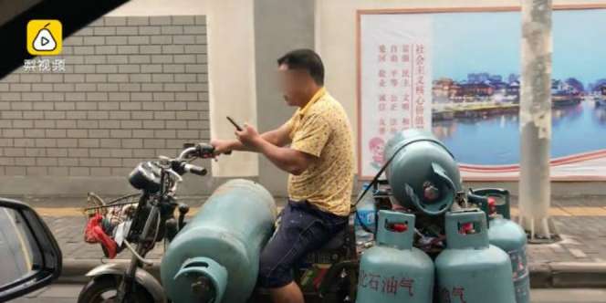 Heboh Pengantar Tabung Gas Main Ponsel Sambil Bawa Motor