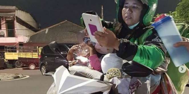 Mengharukan, Driver Gojek Ini Kerja Sambil Asuh Anak