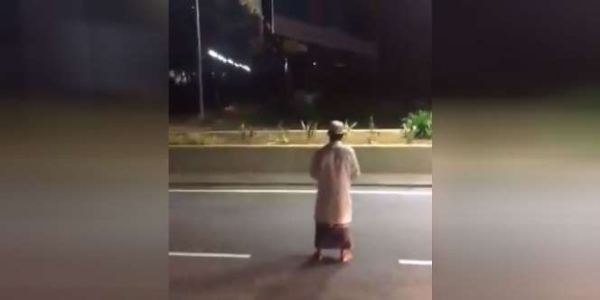 Geger Pria Berpakaian Serba Putih Sholat di Tengah Jalan Raya