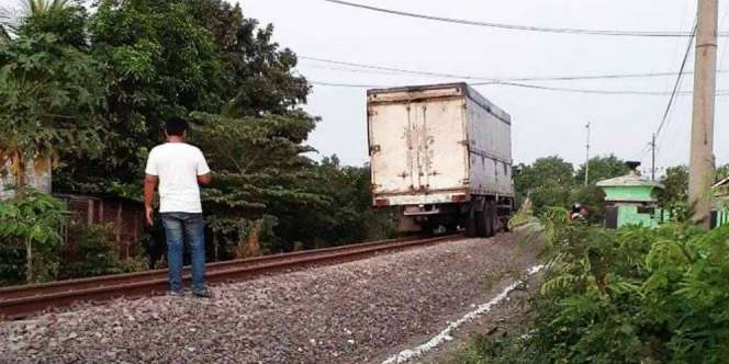 Heboh Truk Tronton Jalan di Atas Rel Kereta Api