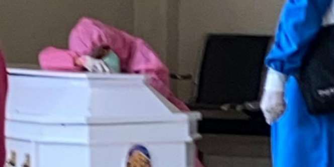 Pakai APD, Istri Ketua IDI Papua Barat Temani Jasad Suami Tercinta 