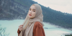 Berpose di Atas Batu, Ririe Fairus Berbalut Gaun Merah Menyala